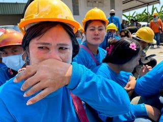 Workers respond while sitting on the ground after a strong earthquake hit in Central -Myanmar on Friday